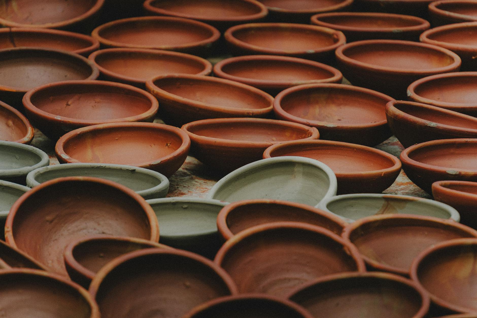 Reihen handgefertigter Tonschalen in verschiedenen Farbtönen