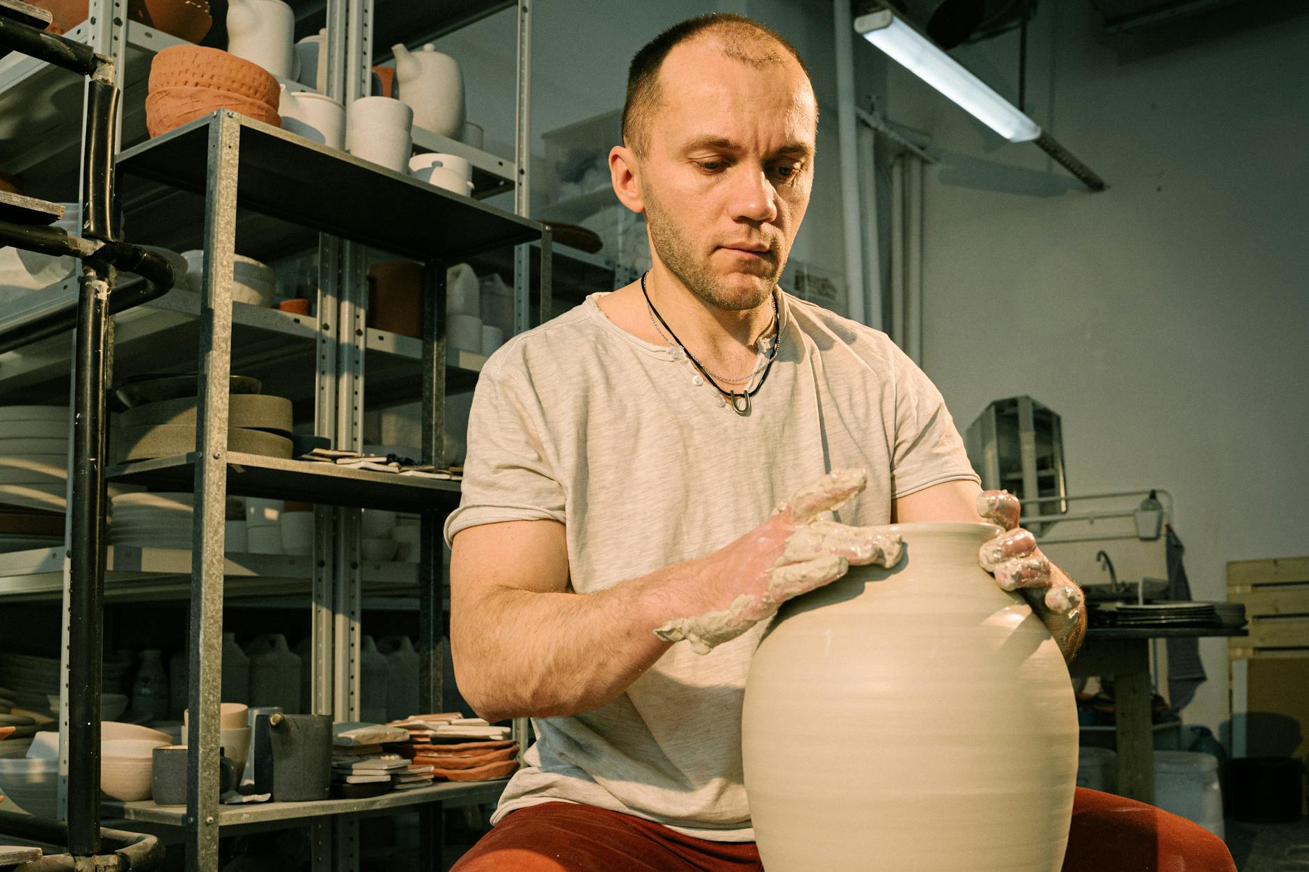 Keramiker prüft eine fertige handgefertigte Vase im Werkstattatelier